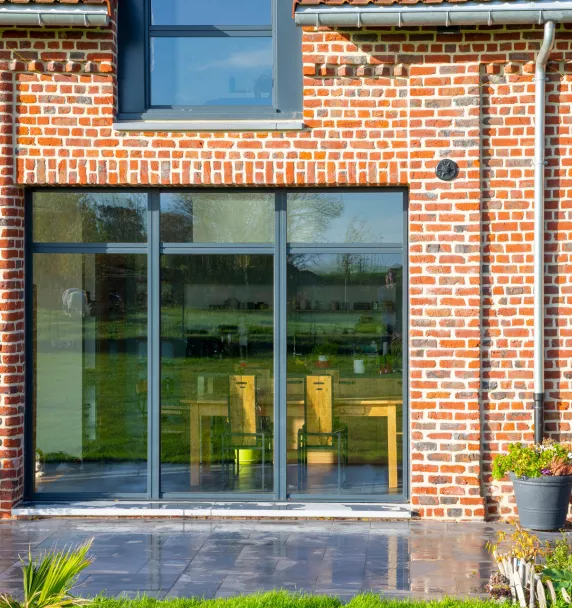 vue depuis la terrasse d'une maison en brique avec menuiserie aluminium