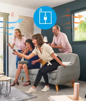 Quatre personnes enthousiastes jouent à un jeu vidéo interactif dans un salon, entourées d'icônes illustrant une connectivité sans fil.
