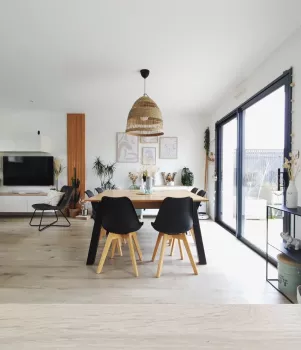 Salon avec table à manger et baie vitrée sur la droite.
