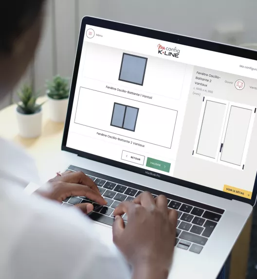 Ordinateur portable affichant un configurateur de fenêtres, utilisé par une personne pour sélectionner et personnaliser des fenêtres, dans un environnement de bureau avec des plantes d'intérieur en arrière-plan.