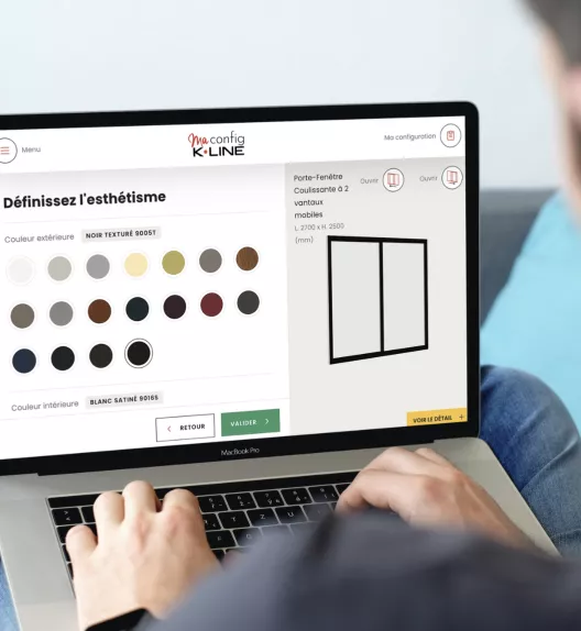 Ordinateur portable affichant un configurateur de porte-fenêtre, l'utilisateur sélectionne des options de couleur, confortablement assis.