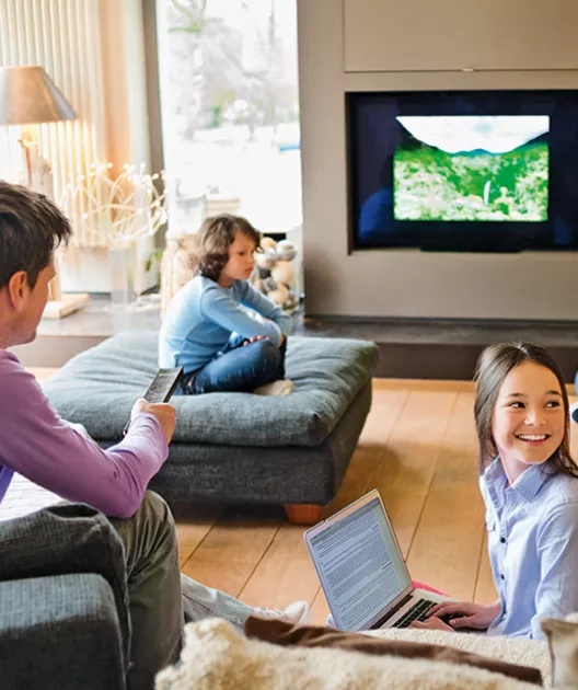 Grande baie vitrée encadrant une piscine extérieure, avec une personne floue marchant à gauche, dans un salon élégant doté de meubles modernes.