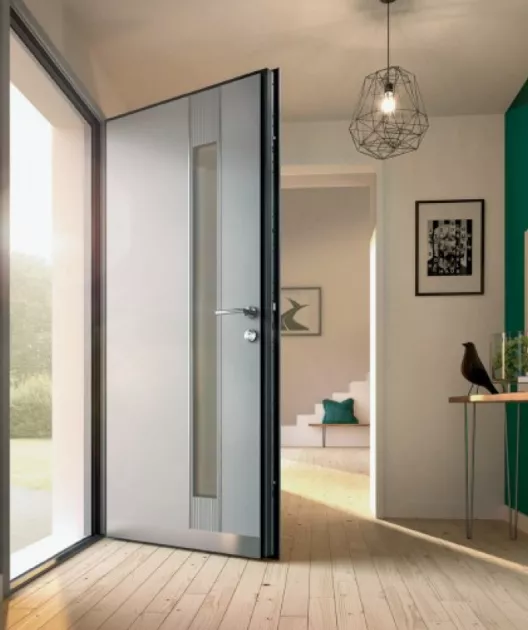 Porte grise ouverte menant à un intérieur moderne avec des escaliers, un cadre photo et une décoration élégante.