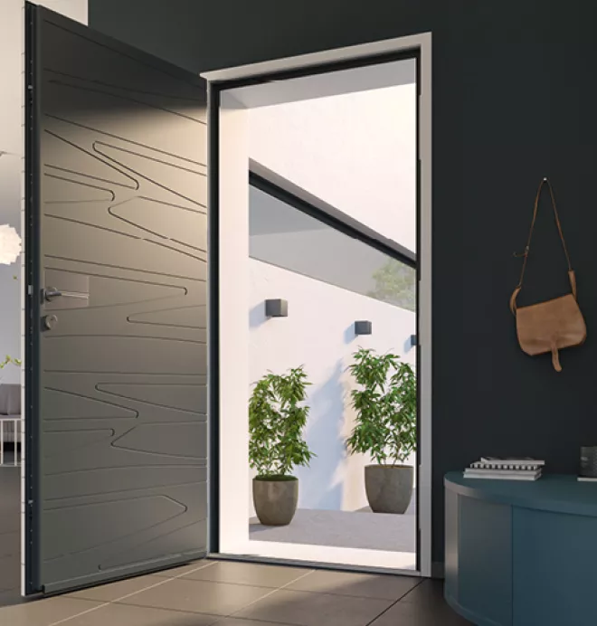 Porte moderne ouverte, dévoilant une cour contemporaine avec murs blancs, deux plantes en pots, et lumière naturelle. À l'intérieur, une table décorée et un sac suspendu au mur.