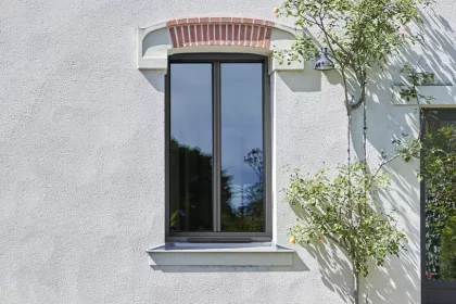 Fenêtre avec Volet Roulant Solaire. Le panneau solaire est situé sur la partie basse de la fenêtre, sur l'appui fenêtre.